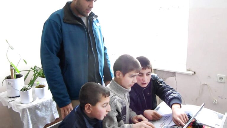 PCV Darryn Glenn helping students learn to use a computer